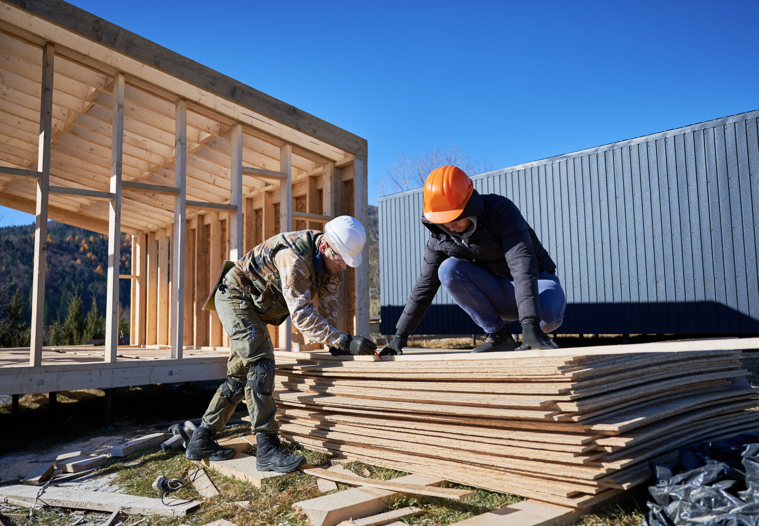 Carpintero cortando una tabla de madera para construir una casa.